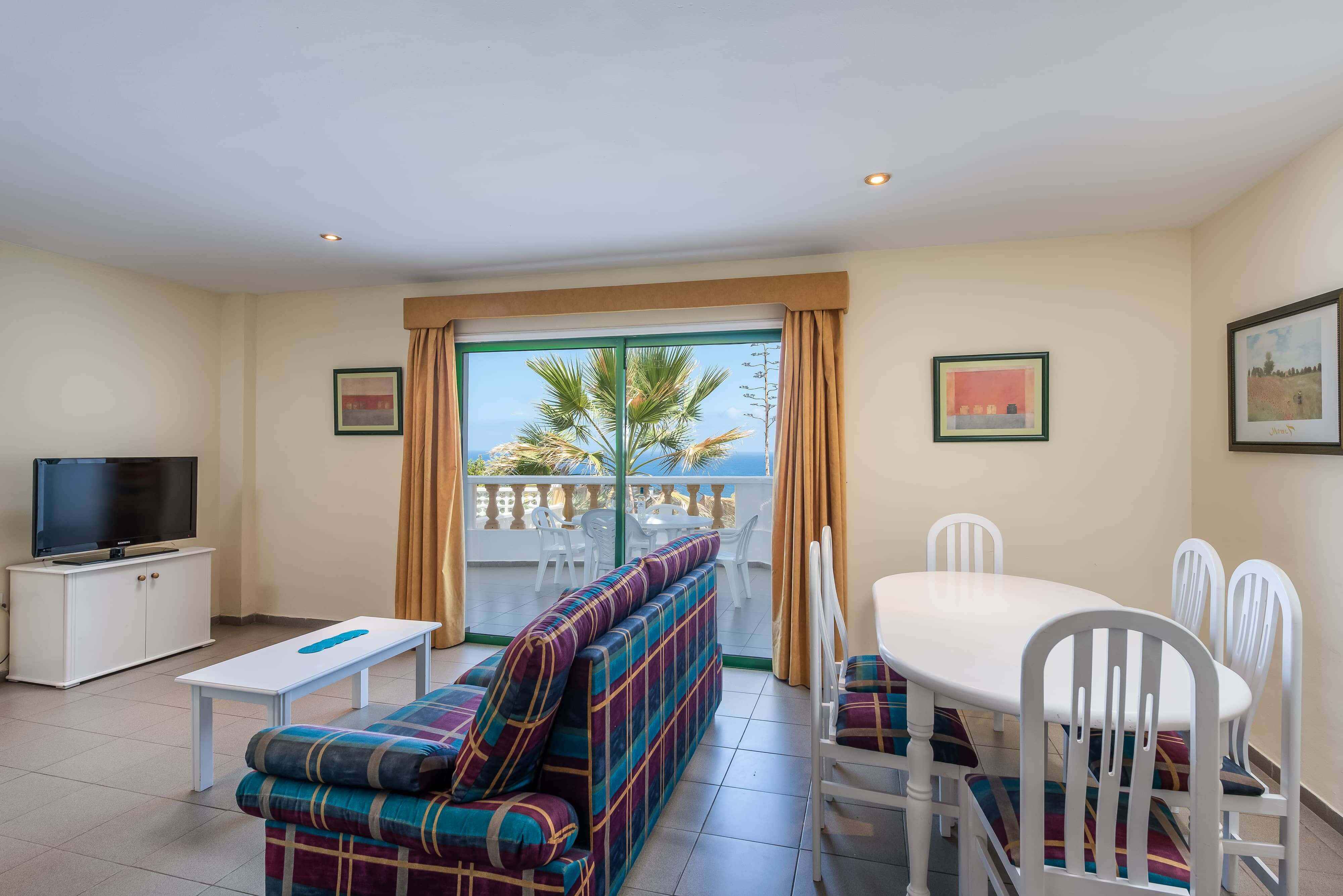 Two- Bed-Room Apartment with Balcony and Sea Views consist of two separate bedrooms, one double and two twins, a large sofa bed in the living area, a private bathroom and a modern fully-fitted kitchen